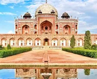 Red sandstone mausoleum with a central white marble dome and symmetrical arches, reflected in the foreground pool.
